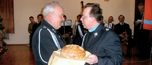 Ks. STanisłąw Szczygieł w momencie przekazywania chleba Stanisławowi Furtakowi z OSP Bełdno.