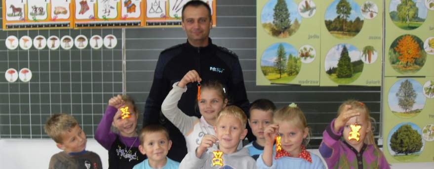 Policjant i obdarowani odblaskami uczniowie klasy pierwszej PSP w Bytomsku.